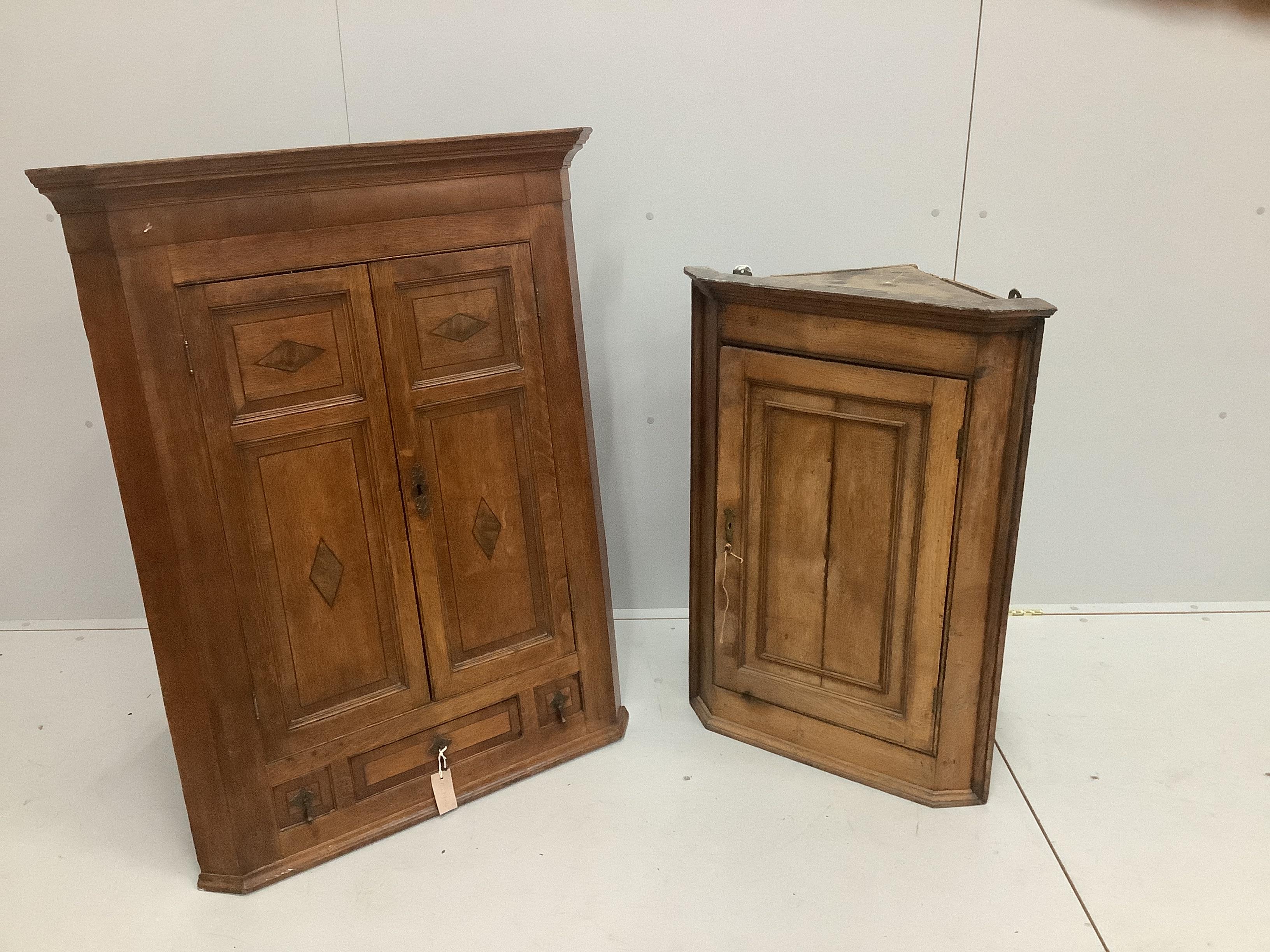 A George III inlaid oak hanging corner cupboard, width 87cm and a similar plainer example, width 62cm